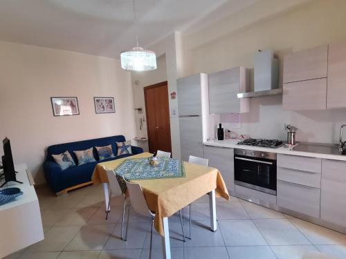 a kitchen and living room with a table and a couch at Appartamento Relax in centro in Capo dʼOrlando