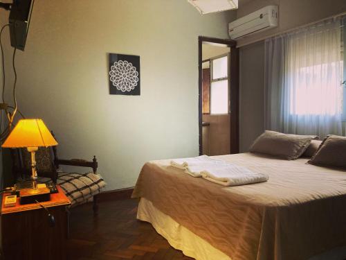 a bedroom with a bed with a lamp and a window at Quebrada Mansa in Nono