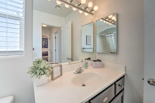 Un baño blanco con lavabo y espejo. en Central Lake Havasu City House Grill and EV Charger, en Lake Havasu City