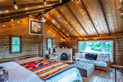 Blockhausschlafzimmer mit einem Bett und einem Kamin in der Unterkunft Li'l Ranch - Nature Lovers Retreat TEX MEX Log home in Wiarton