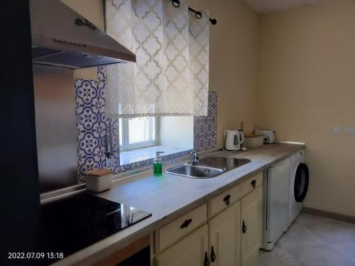 a kitchen counter with a sink and a window at Cantinho do Préstimo in Águeda