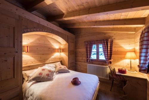 a bedroom with a bed in a wooden room at Chalet Bait del Papi in Madonna di Campiglio