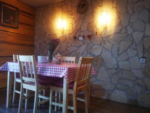 een tafel en stoelen in een kamer met een stenen muur bij PLITVICE MAGIC in Rudanovac