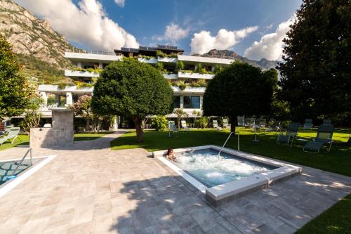 une personne dans une piscine devant un bâtiment dans l'établissement Hotel La Fiorita, à Limone sul Garda