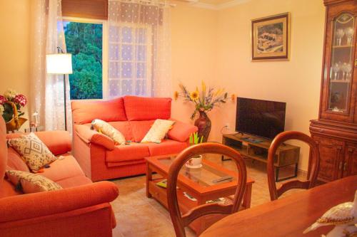 a living room with a red couch and a tv at A Casa de Carballo in Meis