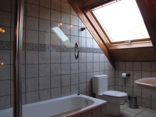 a bathroom with a tub and a toilet and a skylight at Casa Rural Burret in Ochagavía