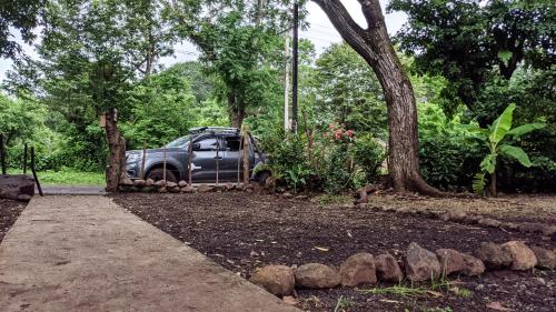 a truck parked in a garden next to a tree at Wood Cabin - Cabana Maderas in Balgue