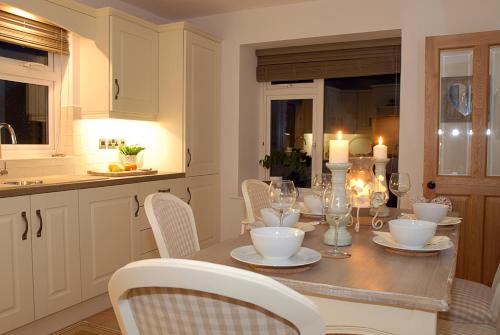 a kitchen with a table with chairs and candles on it at Coolbeg Farmhouse in Maguires Bridge