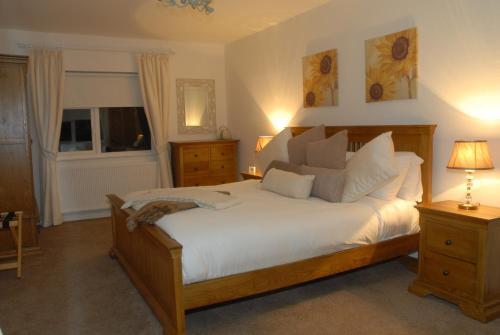 a bedroom with a large bed with white sheets and pillows at Coolbeg Farmhouse in Maguires Bridge