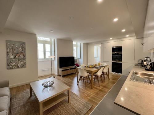 a living room with a table and a kitchen at Faro Design 7 by Homing in Faro