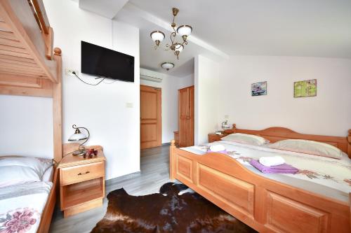 a bedroom with two beds and a flat screen tv at Farm Stay Peternelj in Ilirska Bistrica