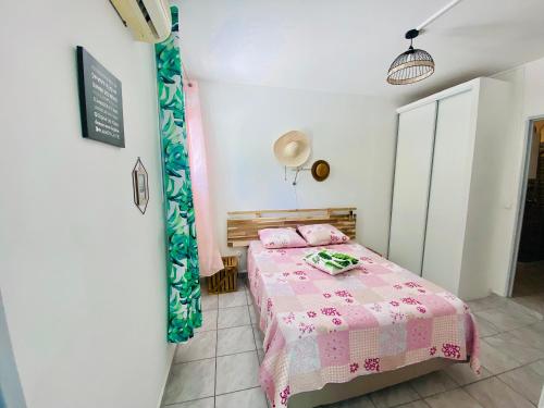 sypialnia z łóżkiem z różowym kocem w obiekcie Gites Les 7 C w mieście Le Gosier