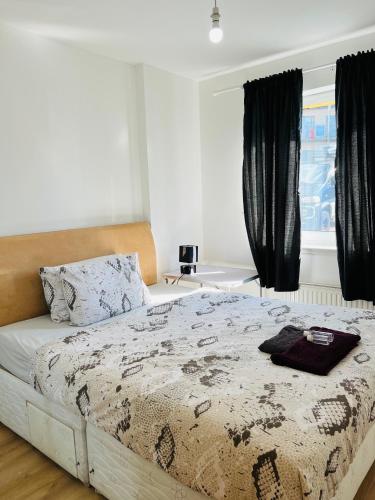 1 dormitorio con cama y ventana en FABULOUS 2BED 2BATH Ground Floor SERVICED ACCOMMODATION Near CITY en Edimburgo