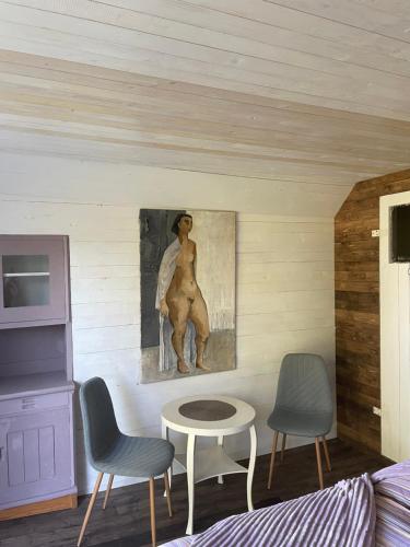 a room with two chairs and a painting on the wall at The Old Henhouse in Tollarp