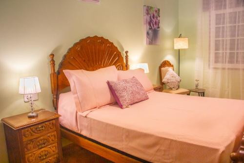 a bedroom with a large bed with pink pillows at A Casa de Carballo in Meis