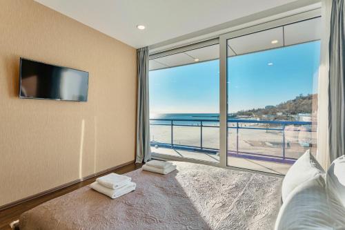 a bedroom with a large window with a view of the beach at Марістелла Морська Перлина in Odesa