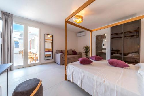 una camera da letto con un grande letto con cuscini rosa di Murieri Rooms a Otranto