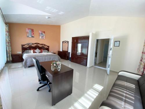 a bedroom with a bed and a desk and a couch at Hotel Lomas Inn in Gran Puerto