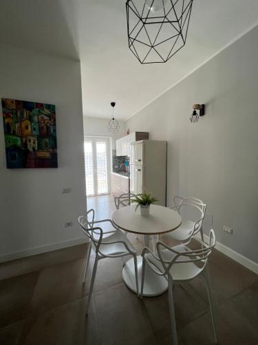 a dining room with a white table and chairs at La Casa Dei Nonni in Matera
