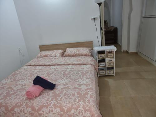 a bedroom with a bed with a pink sock on it at Tannous Aparthotel in Haifa