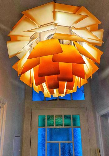 a large orange chandelier hanging from a ceiling at 3 Zimmer Ferienwohnung Burghof mit Balkon im Herzen Flensburgs in Flensburg