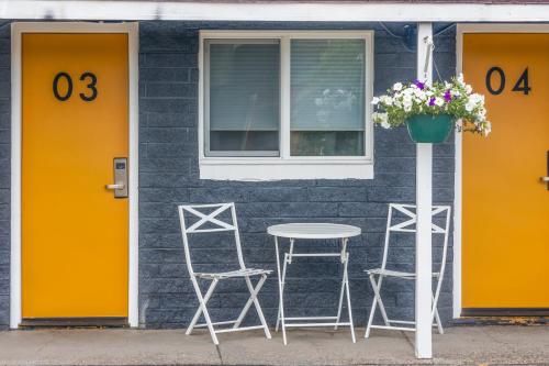 a table and two stools outside of a house at Minecart Motor Lodge in Montrose