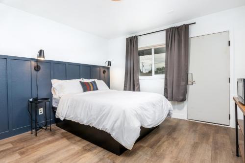 a bedroom with a large bed with a blue headboard at Minecart Motor Lodge in Montrose