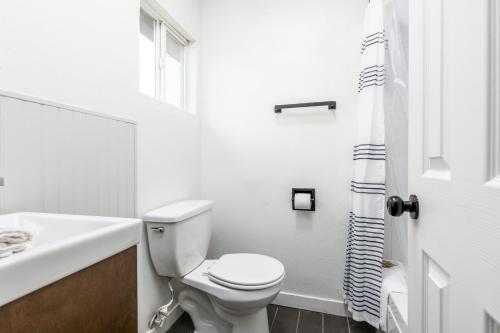 a white bathroom with a toilet and a sink at Minecart Motor Lodge in Montrose