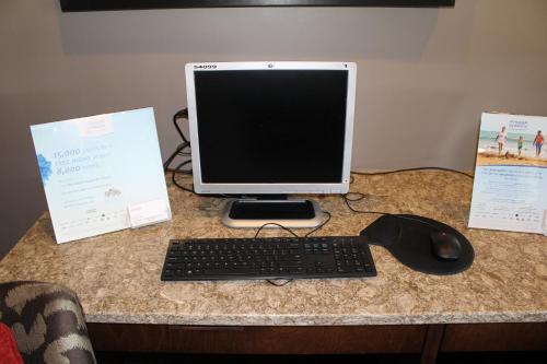 a computer monitor and a keyboard and mouse on a desk at Ramada by Wyndham Campbell River in Campbell River