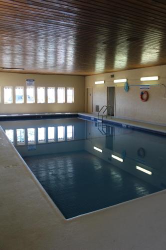 an empty swimming pool in a building with a pool at Ramada by Wyndham Campbell River in Campbell River