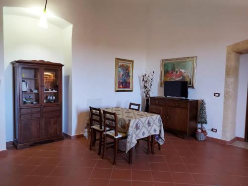 a dining room with a table and chairs and a tv at LA VILLA DEL CONTE in Barletta