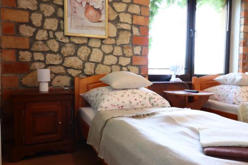 a bedroom with a bed and a stone wall at Karczma Pod Jesionem in Brdów