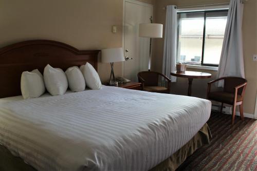 a hotel room with a large bed and a window at Ramada by Wyndham Campbell River in Campbell River
