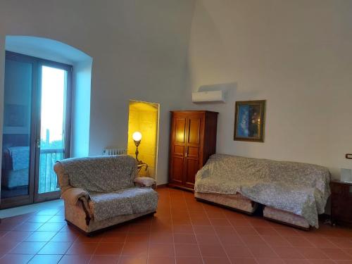 a bedroom with a bed and a chair and a window at LA VILLA DEL CONTE in Barletta