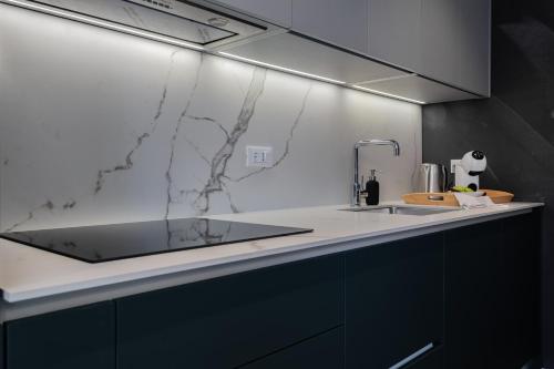 a kitchen with a marble counter top and a sink at Petit Palace in Zadar