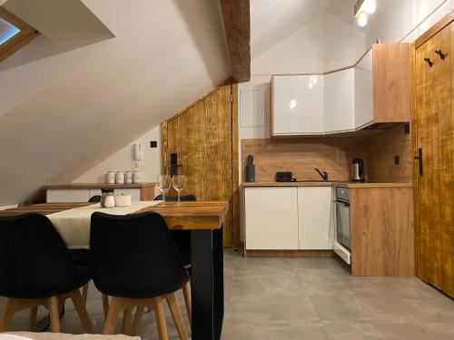 a kitchen with white cabinets and a table and chairs at Apartamenty Zander in Zator