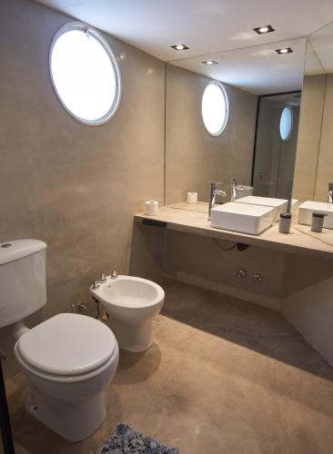 a bathroom with a toilet and a sink and a mirror at Barrancas de Nieva B03 in San Salvador de Jujuy