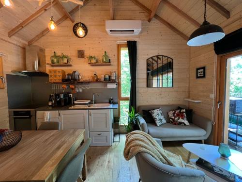 a kitchen and living room in a tiny house at Charmante Cabane dans les arbres avec jacuzzi et sauna in Boismorand