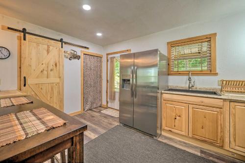 a kitchen with a stainless steel refrigerator and wooden cabinets at Waterfront Cottage in Fort Towson with 2 Decks! in Fort Towson
