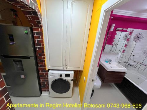 y baño con nevera y lavadora. en Apartament nemaipomenit de frumos Super accesibil, en Botoşani