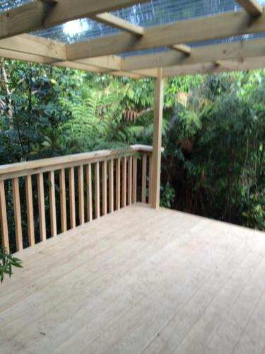 eine Veranda mit einer Holzterrasse mit einem Dach in der Unterkunft Tui Glen in Raurimu Spiral