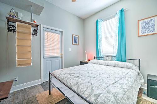 a bedroom with a bed and two windows with blue curtains at Updated Ybor City Duplex about half Mi to Seventh Ave! in Tampa