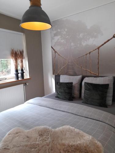 een slaapkamer met een bed met een brug aan de muur bij Secret Wellness Oase in Holten