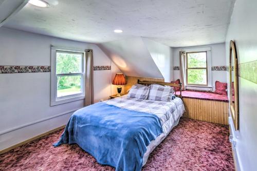 a bedroom with a large bed and two windows at Cozy Ishpeming Cottage with Lake and Park Views! in Ishpeming