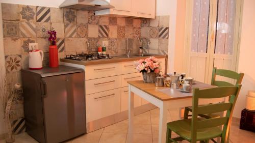 a kitchen with a table and a sink and a refrigerator at aCasetta GuestHouse in Viterbo