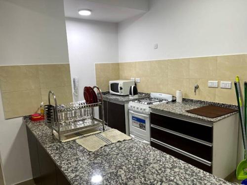 a kitchen with a stove and a counter top at Hermoso departamento,totalmente amoblado c/cochera in Salta