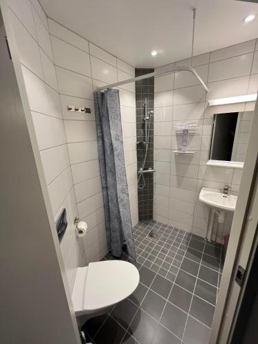 a bathroom with a shower and a toilet and a sink at Senja Living in Stonglandseidet