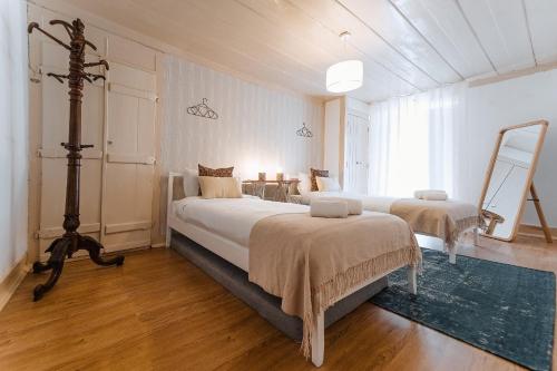 duża sypialnia z 2 łóżkami i stołem w obiekcie Casa Amarela w mieście Óbidos