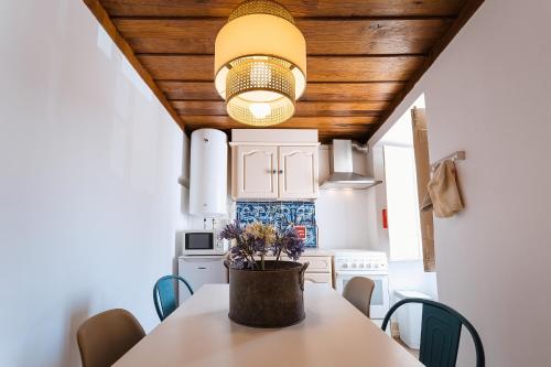 a kitchen with a table with a potted plant on it at Casa Amarela in Óbidos
