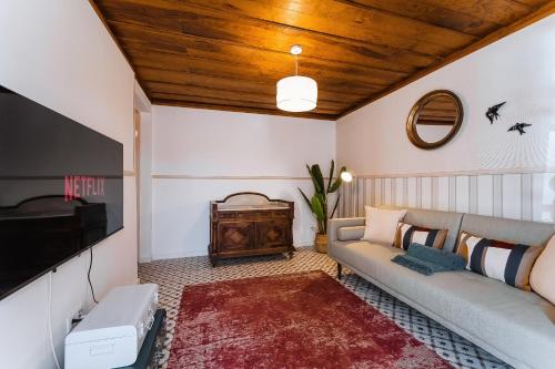 a living room with a couch and a tv at Casa Amarela in Óbidos